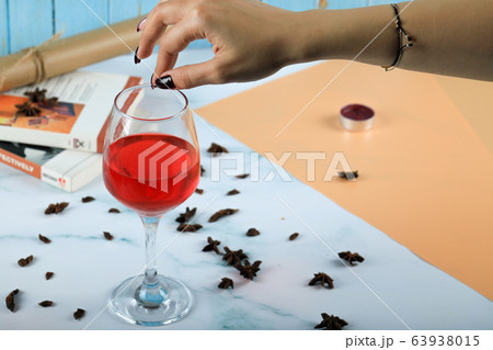 Red rose wine in a glass taken by fingers 63938015