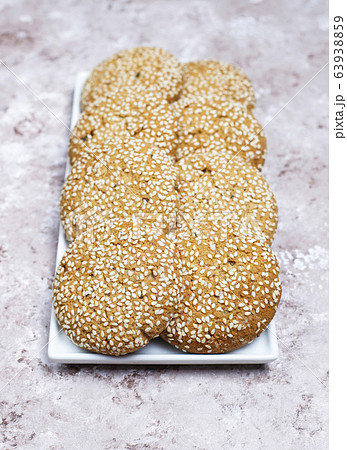 American style sesame seed cookies on light concrete background. 63938859