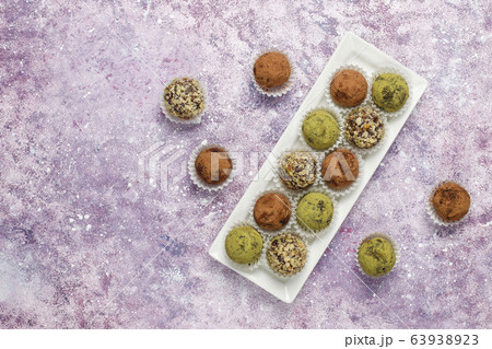 Homemade healthy vegan raw energy truffle balls with dates and walnuts,matcha powder,cocoa powder on light background 63938923