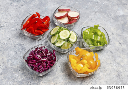 Cutting board with slices of colorful bell peppers on light background. Sliced sweet peppers in different colors, vegetable salad ingredient, cooking healthy food, top view 63938953