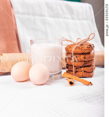 A glass of milk with caramel cookies and raw eggs A glass of milk with caramel cookies and raw eggs 63939159
