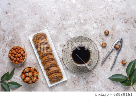 Delicious sweet chocolate cake roll with hazelnut cream and hazelnuts,top view Delicious sweet chocolate cake roll with hazelnut cream and hazelnuts,top view 63939161