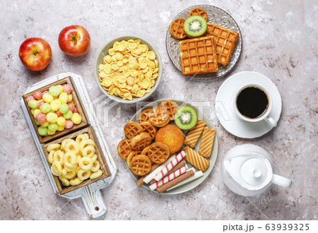 Breakfast with various sweets,wafers,corn flakes and a cup of coffee,top view Breakfast with various sweets,wafers,corn flakes and a cup of coffee,top view 63939325