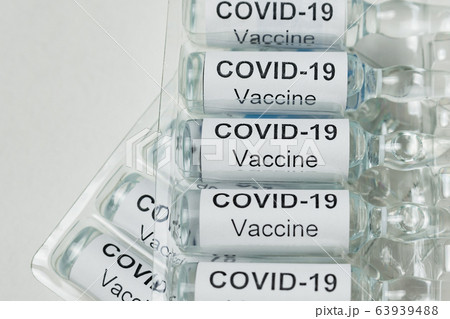 Ampoules with vaccine with label Covid-19 on white 63939488