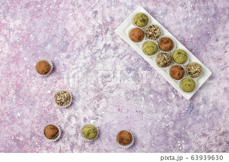 Homemade healthy vegan raw energy truffle balls with dates and walnuts,matcha powder,cocoa powder on light background 63939630