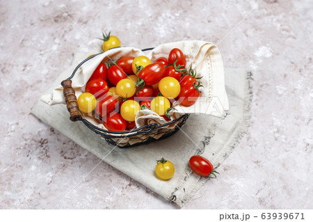 Cherry tomatoes of various colors,yellow and red cherry tomatoes in a basket on light background 63939671