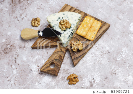 blue cheese on wooden cutting board with honey and walnuts blue cheese on wooden cutting board with honey and walnuts 63939721