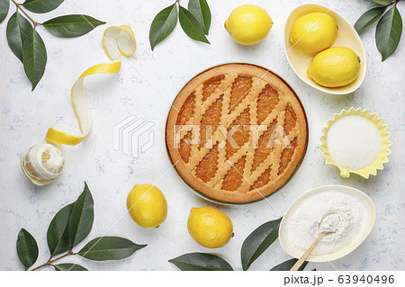 Delicious lemon pie with fresh lemons on light background,top view 63940496