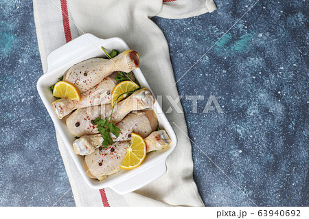 Chicken legs with spices and salt ready for cooking on cutting board. 63940692