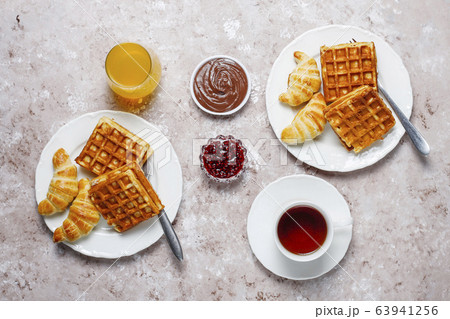 Delicious breakfast with coffee, orange juice, waffles,croissants,jam,nut paste on light background,top view 63941256
