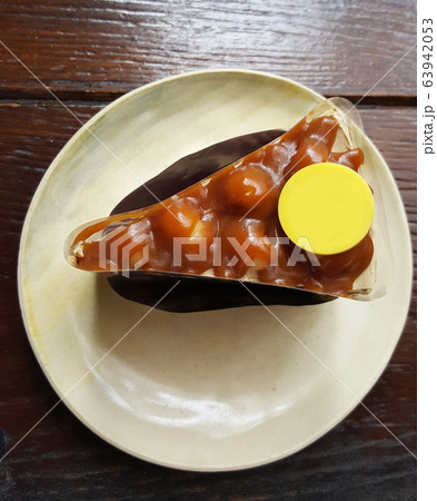 a slice of Macadamia pistachio and almond nuts cake serving with cocoa powder and yellow sweet sugar plate on circle ceramic tray on dark brown table at coffee gourmet cafe, graphic design component,  63942053