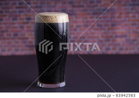 A Guinness dark Irish dry stout beer glass that A Guinness dark Irish dry stout beer glass that 63942563