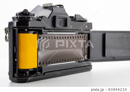 Single lens reflex camera and a film roll on a white background. 63944210
