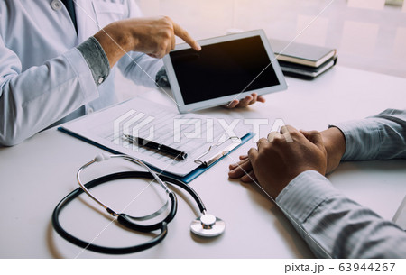 Asian doctor talking the patient at clinic while 63944267