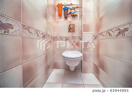 Toilet bowl in tiny toilet room with tile wall Toilet bowl in tiny toilet room with tile wall 63944993