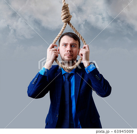 Depressed businessman wearing rope loop committing suicide. Depressed businessman wearing rope loop committing suicide. 63945009