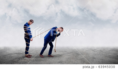 Upset businessman pulls tied himself with a rope. Upset businessman pulls tied himself with a rope. 63945030