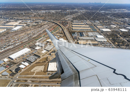 Aerial view of cargo trains and contrainers at the terminal railway which look through airplane windows,Aircraft Wing over cityscape,street and express way at the afternoon time,transportation concept Aerial view of cargo trains and contrainers at the terminal railway which look through airplane windows,Aircraft Wing over cityscape,street and express way at the afternoon time,transportation concept 63948111