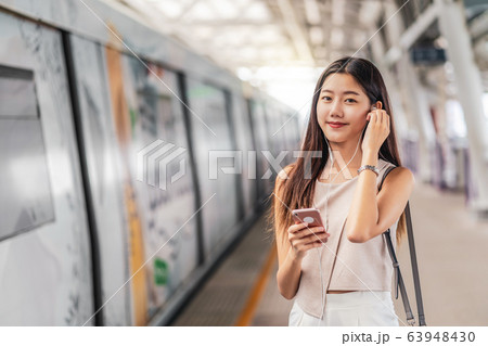 Young Asian woman passenger using and listening music via smart mobile phone in subway train station, japanese,chinese,Korean lifestyle, leisure and daily life, commuter and transportation concept Young Asian woman passenger using and listening music via smart mobile phone in subway train station, japanese,chinese,Korean lifestyle, leisure and daily life, commuter and transportation concept 63948430
