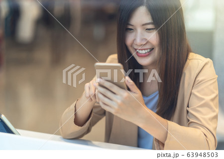 Asian woman using credit card with mobile phone for online shopping in department store over the clothes shop store background, technology money wallet and online payment concept, credit card mockup Asian woman using credit card with mobile phone for online shopping in department store over the clothes shop store background, technology money wallet and online payment concept, credit card mockup 63948503