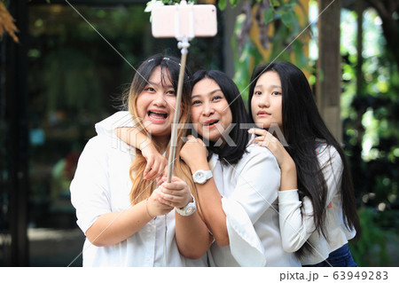 family mom and two daughter take photo family mom and two daughter take photo 63949283