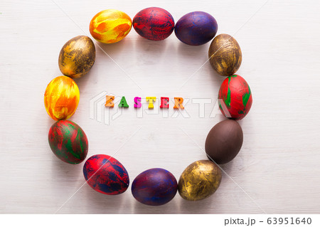Multi-colored wooden letters making up the words happy easter and decorative colourful eggs on a white background with copy space. 63951640