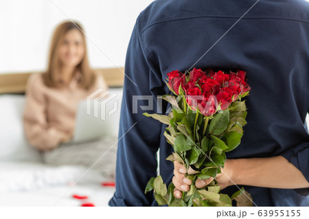 Man hiding flower at back. 63955155
