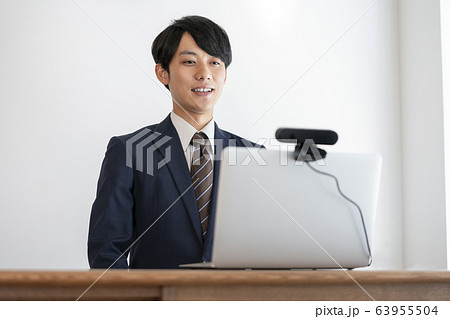 ウェブカメラを使ってオンライン面接を受ける若い男性　就活イメージ 63955504