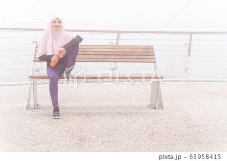 Confident sportswoman on the bench stock photo Confident sportswoman on the bench stock photo 63958415