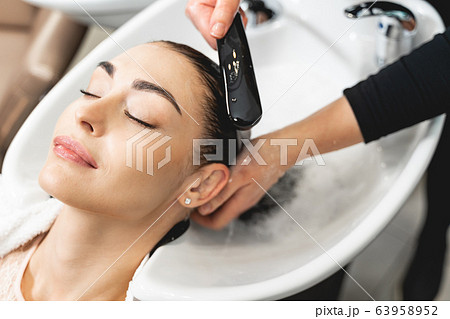 Attractive brunette girl enjoying beauty procedures in salon Attractive brunette girl enjoying beauty procedures in salon 63958952