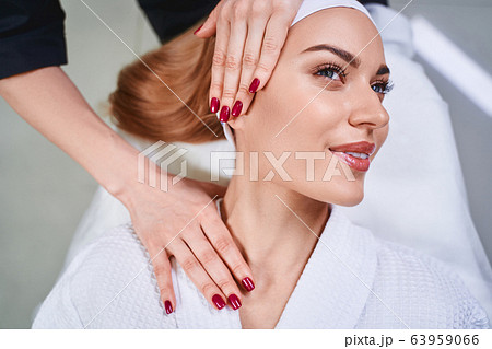 Smiling woman during face massage stock photo Smiling woman during face massage stock photo 63959066