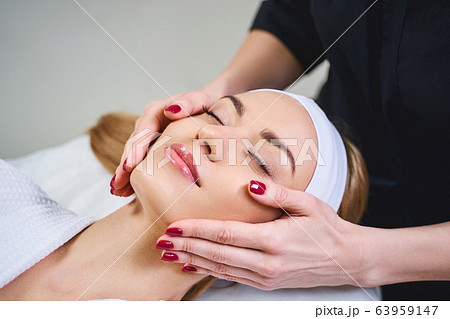 Young woman during face massage stock photo Young woman during face massage stock photo 63959147