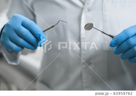 Dentist with tools in hands stock photo Dentist with tools in hands stock photo 63959762
