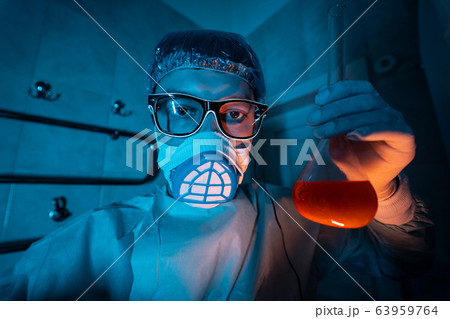 Young male researcher carrying out scientific experiment. Young male researcher carrying out scientific experiment. 63959764