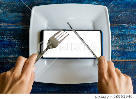 Mobile smart phone served as dinner on white plate. Concept of information absorption process, Internet addiction. Dependence on the phone, smartphone. The mobile or cell phone addiction concept top Mobile smart phone served as dinner on white plate. Concept of information absorption process, Internet addiction. Dependence on the phone, smartphone. The mobile or cell phone addiction concept top 63961946