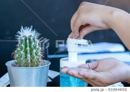 Young woman uses her hand to press hand sanitizer bottle to clean her hand. Hand sanitizer alcohol gel rub clean hands hygiene prevention of coronavirus virus outbreak. 63964650