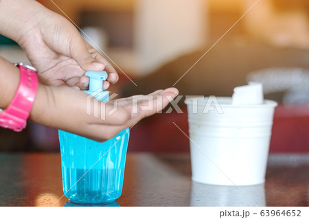 Young woman uses her hand to press hand sanitizer bottle to clean her hand. Hand sanitizer alcohol gel rub clean hands hygiene prevention of coronavirus virus outbreak. Young woman uses her hand to press hand sanitizer bottle to clean her hand. Hand sanitizer alcohol gel rub clean hands hygiene prevention of coronavirus virus outbreak. 63964652