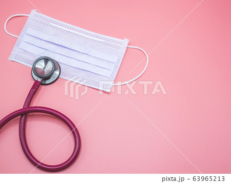 mask and stethoscope placed on a pink background 63965213