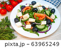 Greek salad with tomatoes, cucumbers and feta cheese with olives on the table 63965249