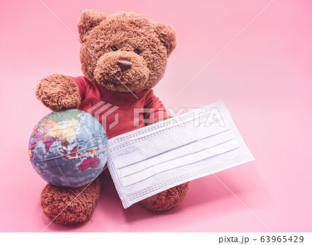 Brown teddy bear wearing a surgical mask protects 63965429
