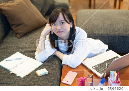 自宅のソファでくつろぐ若い女性 自宅のソファでくつろぐ若い女性 63966204