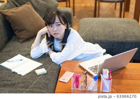 自宅のソファにもたれかかる若い女性 自宅のソファにもたれかかる若い女性 63966270