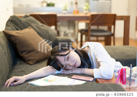 夜リビングのソファに横たわる若い女性 夜リビングのソファに横たわる若い女性 63966325