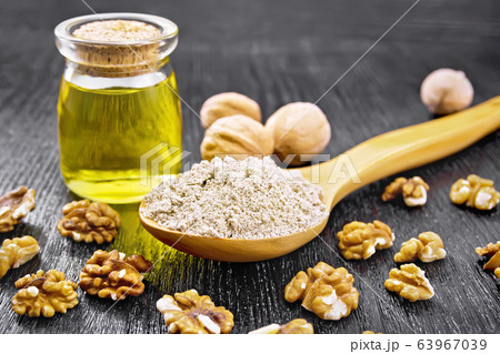 Flour walnut in spoon with oil on board 63967039