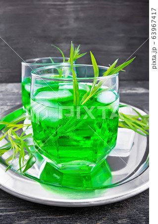 Lemonade Tarragon with ice in two glasses on board 63967417