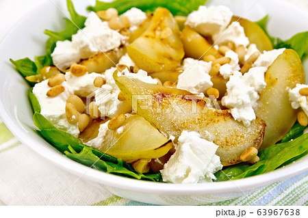 Salad from pear and spinach in dish on napkin 63967638