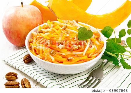 Salad of pumpkin and apple in bowl on light board Salad of pumpkin and apple in bowl on light board 63967648