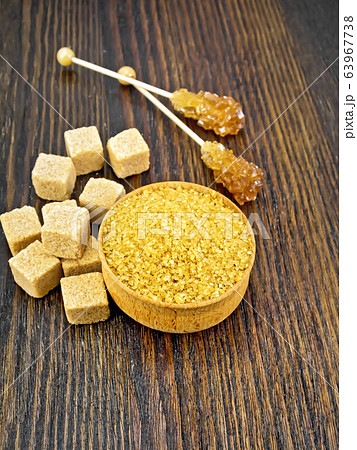 Sugar brown in bowl and crystalline on dark board 63967738