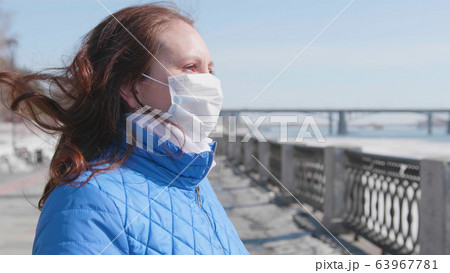 A girl in a protective mask on the street. Prevention and protection of health and safety of life. Coronavirus N1H1, covid-19, pandemic in the world. A girl in a protective mask on the street. Prevention and protection of health and safety of life. Coronavirus N1H1, covid-19, pandemic in the world. 63967781