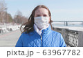 A girl in a protective mask on the street. Prevention and protection of health and safety of life. Coronavirus N1H1, covid-19, pandemic in the world. 63967782